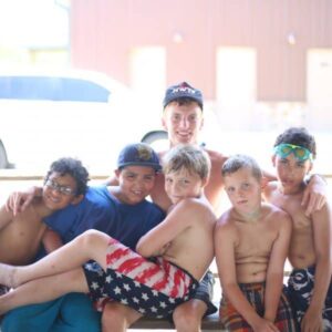 Summer camp boys spending time with their counselor at the Christian youth summer camp Shepherd's Fold Ranch.