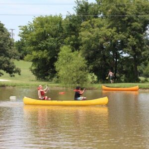 Kids canoeing in pond at Christian youth camp Shepherd's Fold Ranch