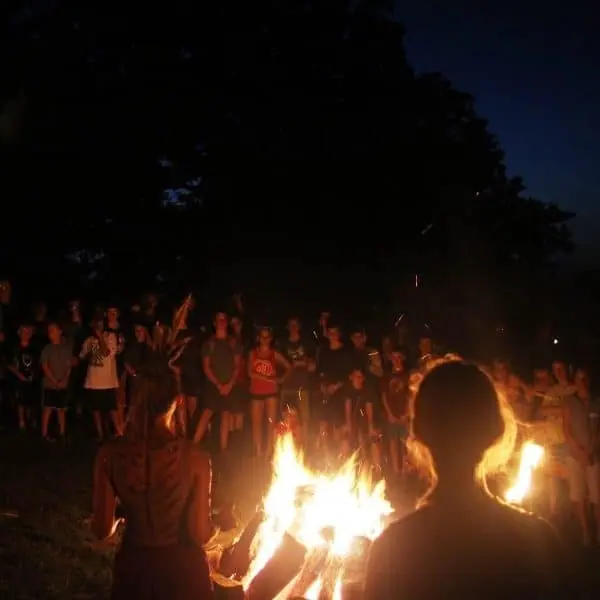 Campfire gathering with crowd at night