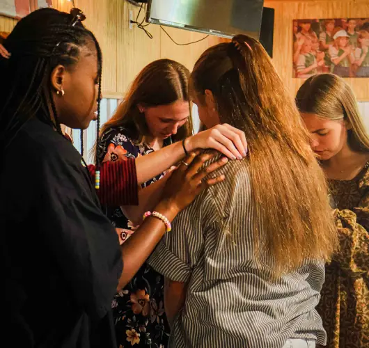 Group of girls gathered in prayer.