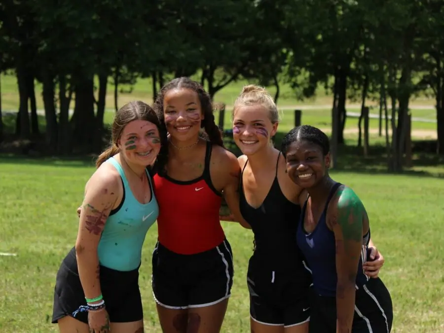 Smiling friends with face paint outdoors.
