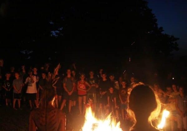 Campfire gathering with crowd at night